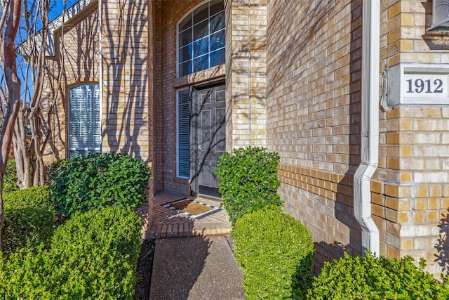 entrance to property featuring brick siding