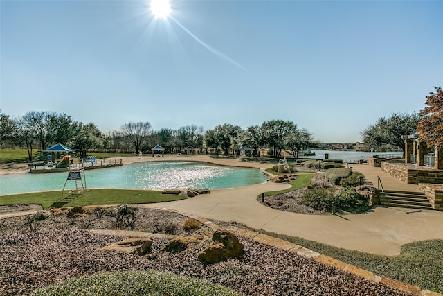 outdoor pool featuring a patio and a water view