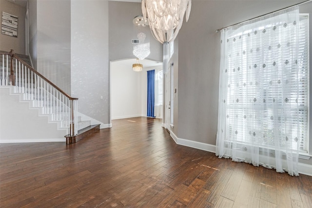 interior space with a wealth of natural light, stairway, and an inviting chandelier