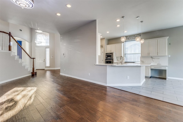 kitchen with recessed lighting, white cabinets, light countertops, and wood finished floors