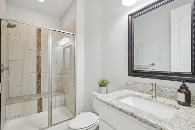 bathroom with vanity, toilet, and a stall shower