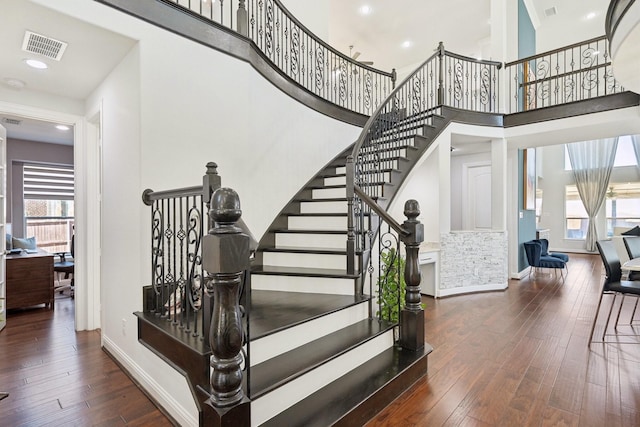 staircase featuring visible vents, baseboards, and hardwood / wood-style flooring