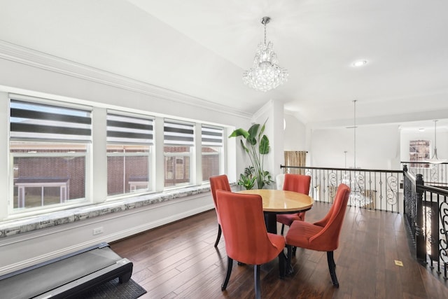 dining room with a notable chandelier, crown molding, dark wood-type flooring, and baseboards