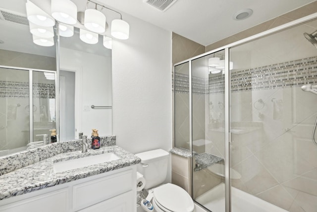 full bathroom featuring visible vents, a shower stall, toilet, and vanity