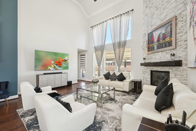 living room with a fireplace, wood finished floors, baseboards, and high vaulted ceiling