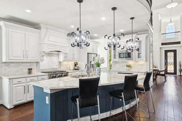 kitchen with custom range hood, a sink, white cabinetry, stainless steel appliances, and dark wood-style flooring