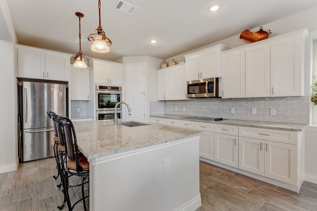 kitchen featuring a sink, visible vents, appliances with stainless steel finishes, and wood tiled floor