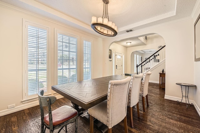 dining space featuring visible vents, baseboards, arched walkways, a raised ceiling, and dark wood-style flooring