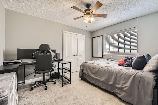 carpeted bedroom featuring baseboards, a ceiling fan, a closet, and a textured ceiling