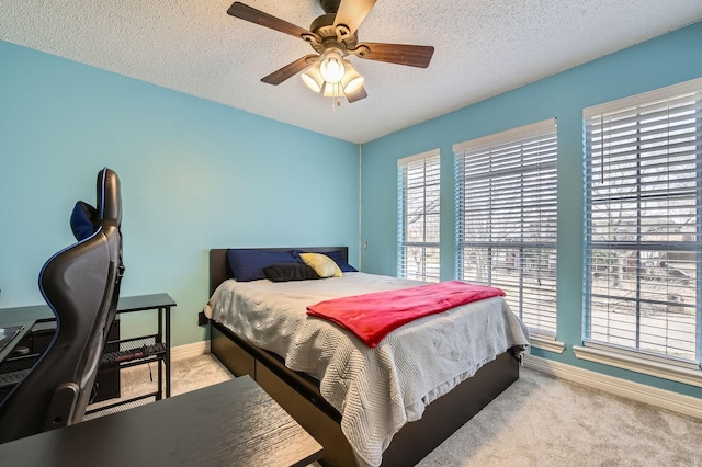 bedroom with a ceiling fan, carpet, baseboards, and a textured ceiling