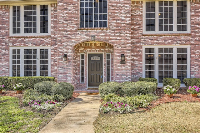 doorway to property featuring brick siding