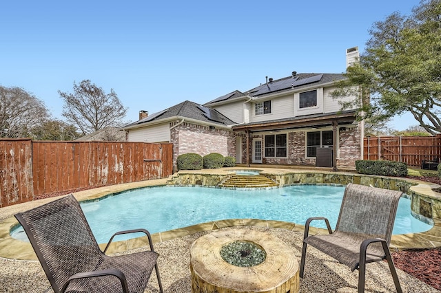 view of swimming pool featuring a fenced in pool, an outdoor fire pit, a fenced backyard, a patio area, and an in ground hot tub