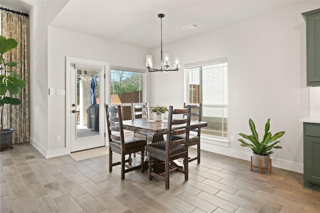 dining room featuring wood finish floors, visible vents, a notable chandelier, and a healthy amount of sunlight