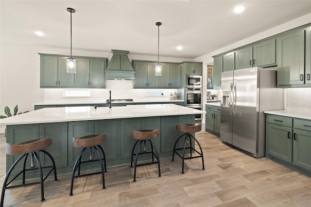 kitchen with green cabinets, a kitchen breakfast bar, custom range hood, and stainless steel appliances