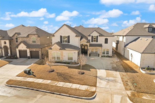 french country style house featuring a garage, a residential view, brick siding, and concrete driveway