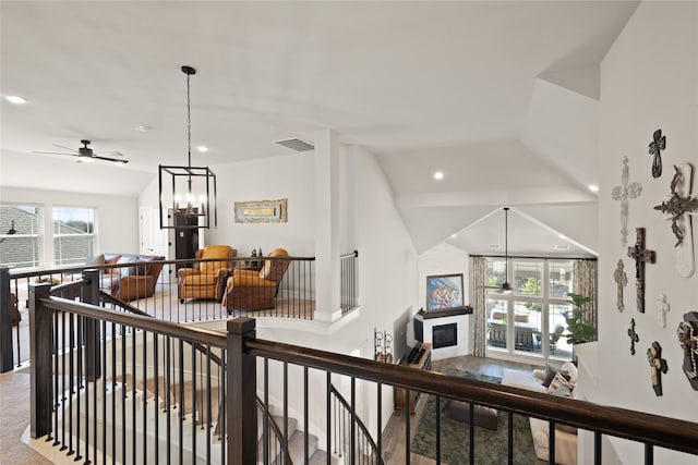 hallway with visible vents, lofted ceiling, an upstairs landing, recessed lighting, and a notable chandelier