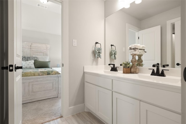 ensuite bathroom with a sink, visible vents, ensuite bath, and double vanity