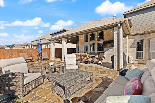 view of patio with outdoor dining area, fence, and an outdoor hangout area