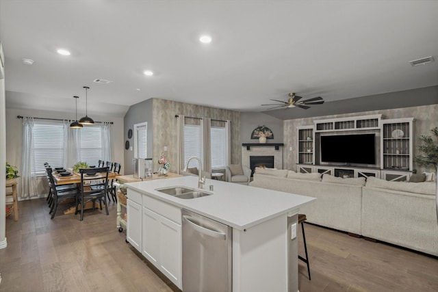 kitchen featuring a sink, visible vents, dishwasher, and light wood finished floors