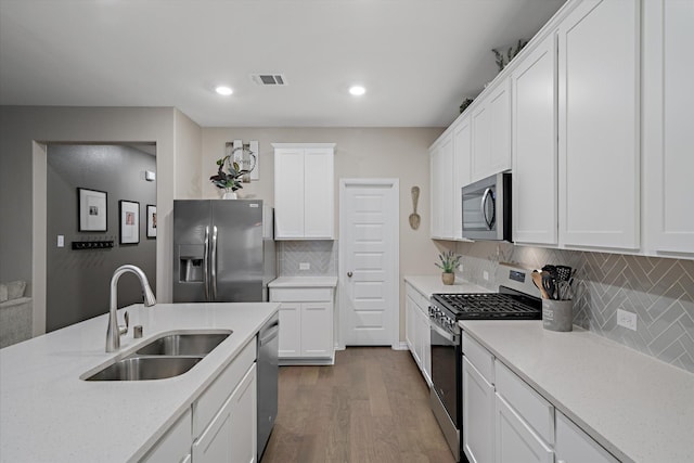 kitchen with dark wood-style floors, visible vents, a sink, stainless steel appliances, and white cabinets