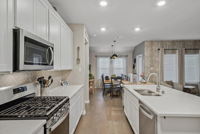 kitchen with white cabinets, visible vents, appliances with stainless steel finishes, and a sink