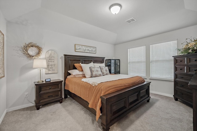 bedroom featuring lofted ceiling, light colored carpet, visible vents, and baseboards