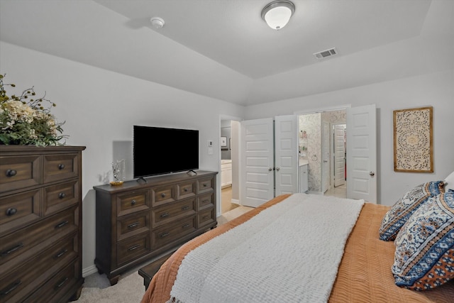 bedroom featuring visible vents, light carpet, and ensuite bathroom