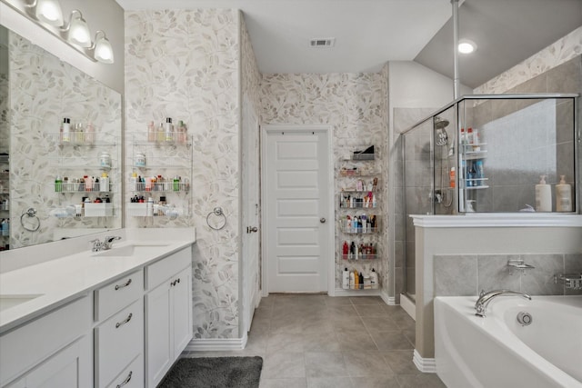 bathroom with double vanity, a garden tub, a shower stall, and wallpapered walls