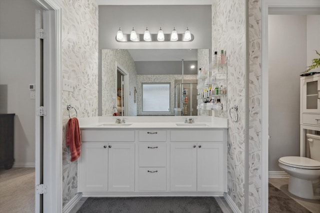 full bath with double vanity, a stall shower, wallpapered walls, and a sink