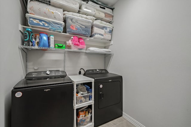 laundry room with light tile patterned floors, baseboards, washing machine and dryer, and laundry area