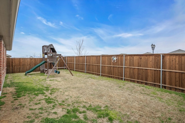 view of yard featuring a fenced backyard and a playground