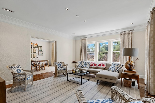 living room featuring visible vents, baseboards, ornamental molding, and a textured wall