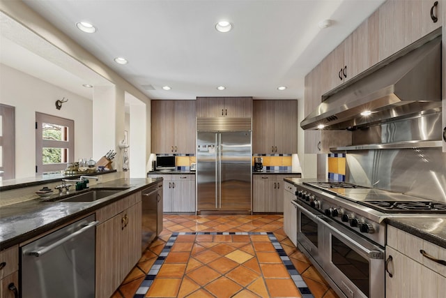 kitchen with under cabinet range hood, recessed lighting, high quality appliances, and a sink