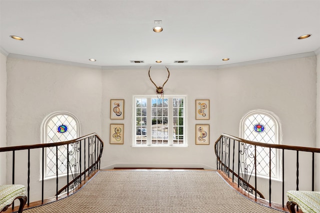 corridor with an upstairs landing, recessed lighting, a wealth of natural light, and ornamental molding