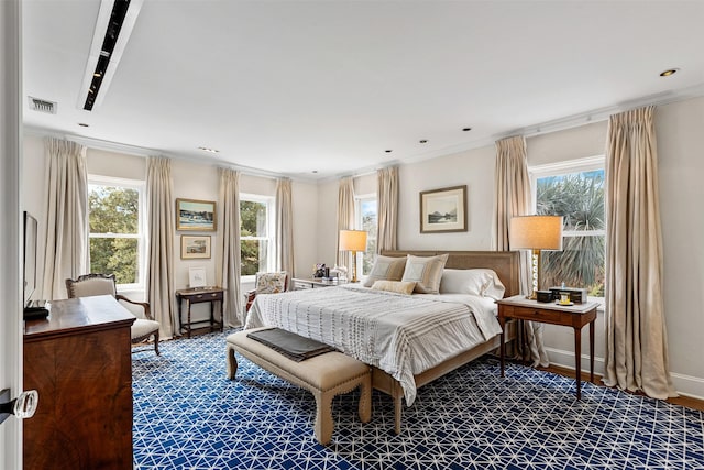 bedroom featuring multiple windows, baseboards, visible vents, and ornamental molding