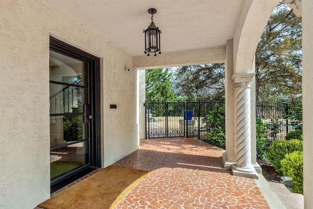 doorway to property featuring stucco siding and fence