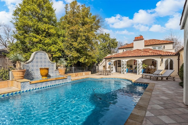 view of swimming pool with a fireplace, a patio area, fence, and a fenced in pool