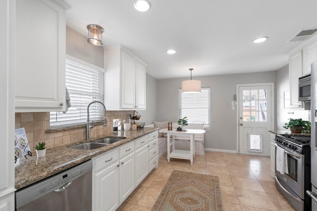 kitchen with a sink, stainless steel appliances, white cabinets, and decorative backsplash