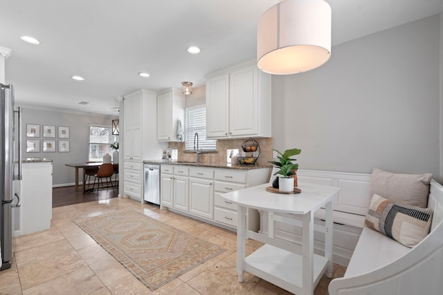 kitchen featuring white cabinets, plenty of natural light, tasteful backsplash, and stainless steel appliances