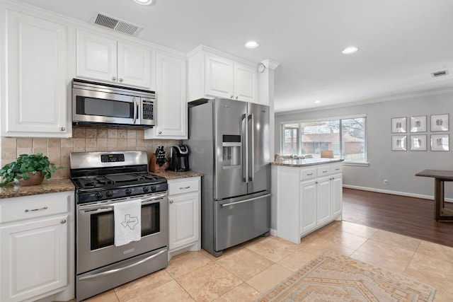 kitchen with white cabinets, backsplash, visible vents, and appliances with stainless steel finishes