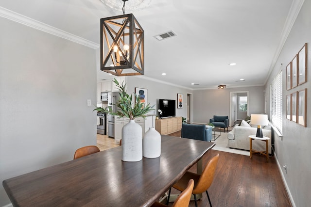 dining area with crown molding, light wood-style flooring, and visible vents