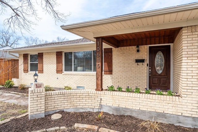 entrance to property with fence and brick siding