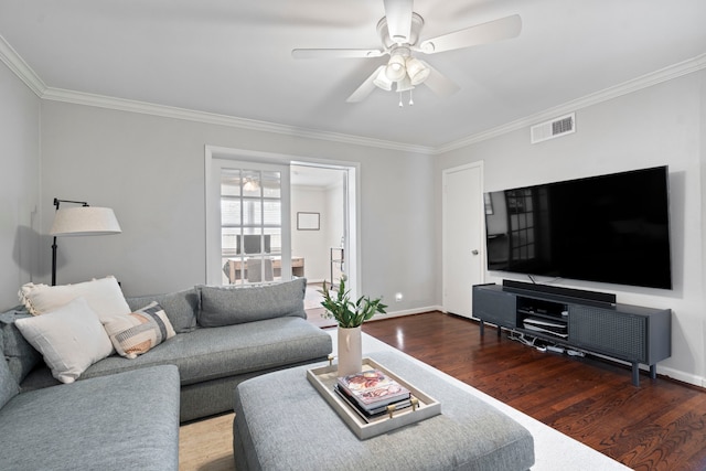 living room with ornamental molding, wood finished floors, visible vents, and ceiling fan