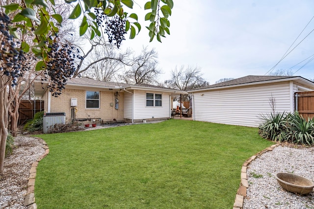 rear view of property with brick siding, a lawn, central AC, and fence