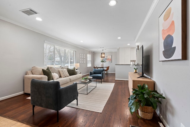 living room featuring dark wood finished floors, crown molding, baseboards, and visible vents