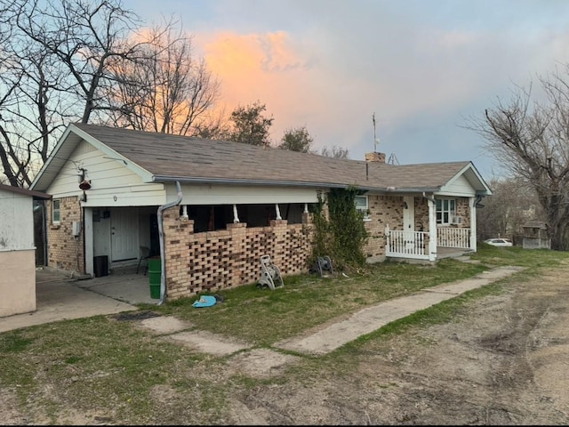 single story home with a porch, brick siding, and a chimney