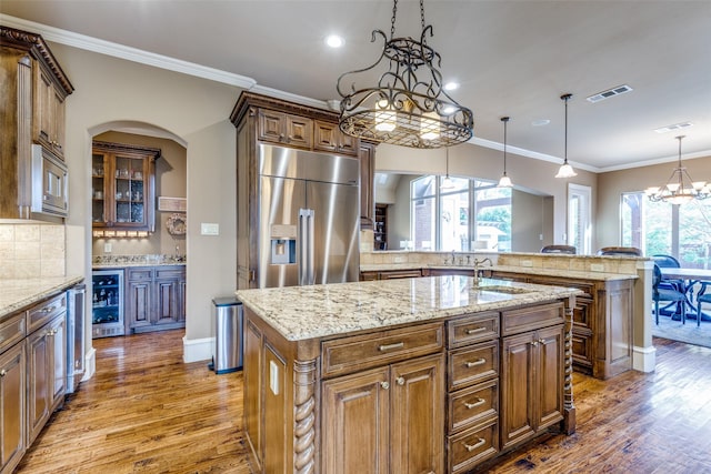 kitchen with beverage cooler, visible vents, an inviting chandelier, appliances with stainless steel finishes, and backsplash