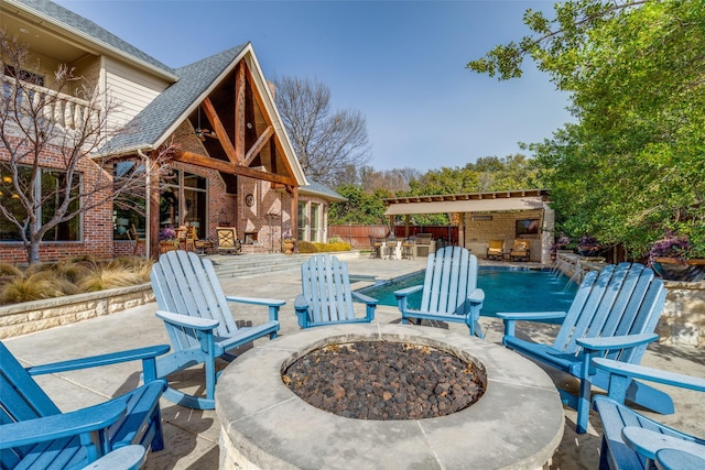 view of patio / terrace featuring a fireplace, fence, outdoor dry bar, and an outdoor fire pit