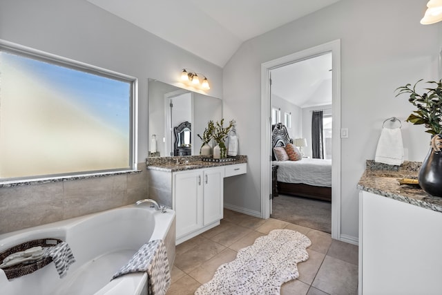 full bath with baseboards, a garden tub, vaulted ceiling, tile patterned floors, and vanity