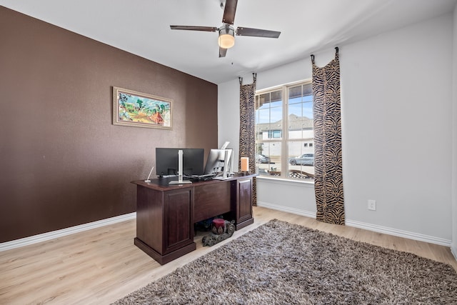 office with a ceiling fan, light wood-style floors, and baseboards